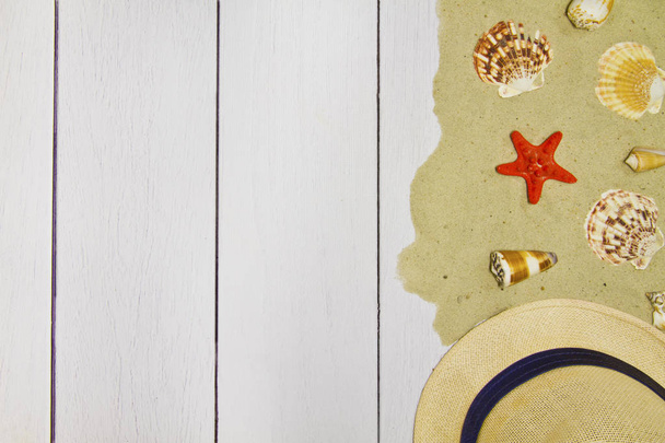 Coquilles de mer, étoiles, chapeau sur fond bois clair avec sable, vue sur le dessus
 - Photo, image