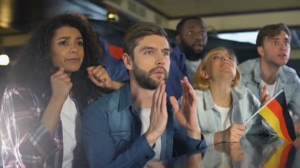 Fans waving German flag, watching sports program in bar, upset about losing game - Filmagem, Vídeo