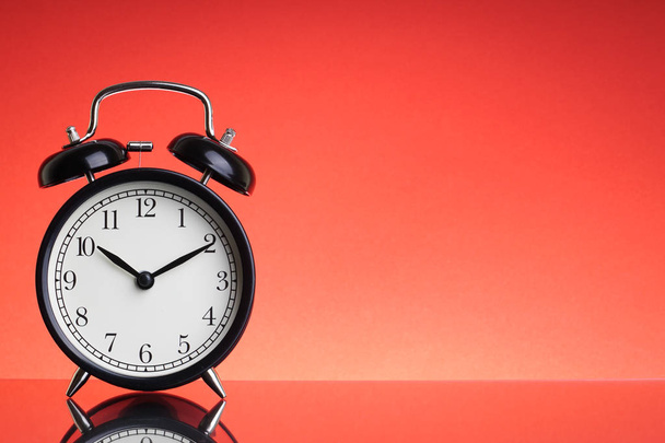 Alarm Clock on red background with selective focus and crop fragment. Business and Copy space concept - Foto, Imagen