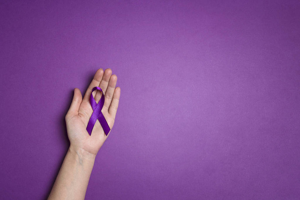 Hand holding Purple ribbons on a p urple background. World epile - Fotoğraf, Görsel