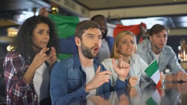 Group of fans watching sports, waving Italian flag in support of national team - Filmagem, Vídeo