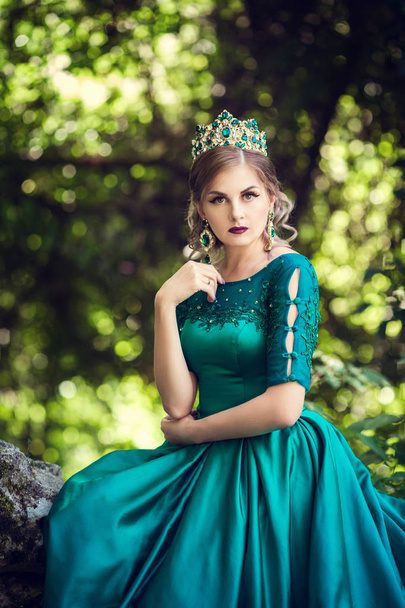 Молода жінка в зеленому платті досліджує чарівний ліс
 - Фото, зображення