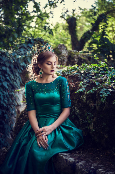 junge Frau in grünem Kleid erkundet Zauberwald - Foto, Bild
