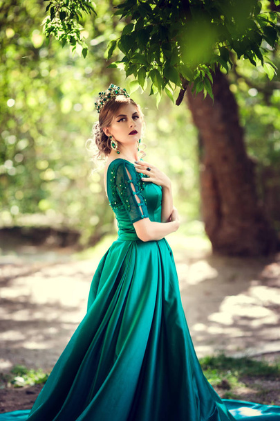 Молодая женщина в зеленом платье исследует волшебный лес
 - Фото, изображение