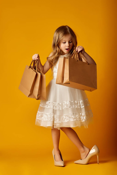 Surprised girl in big high heels with packets - Foto, afbeelding