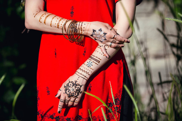 Mehendi na rękach dziewczyn, Kobieta Ręce z brązowym tatuażem mehndi. Dłonie indyjskiej panny młodej z brązowymi tatuażami henny. - Zdjęcie, obraz