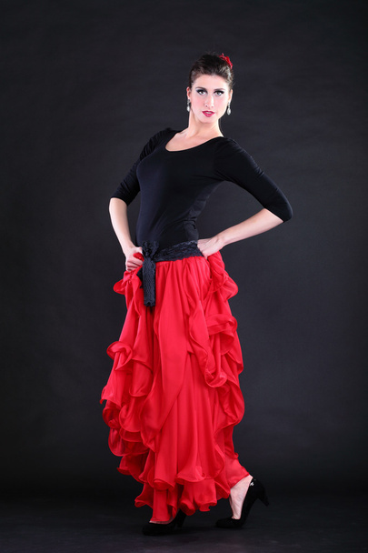 Attractive spanish young woman dancing flamenco over black backg - Foto, Imagen
