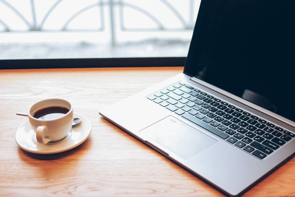 Nyílt laptop és egy csésze kávét az asztalra a kávézóban, freela - Fotó, kép