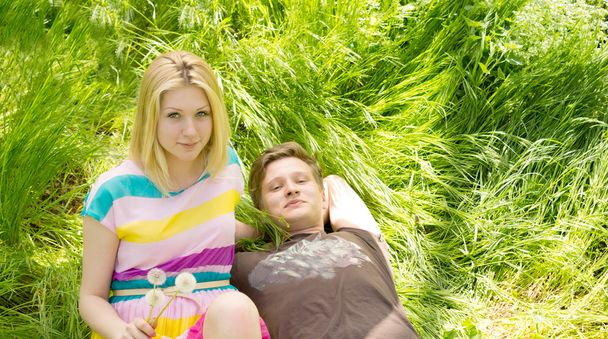 Portrait of a young couple lying on the grass - Fotografie, Obrázek