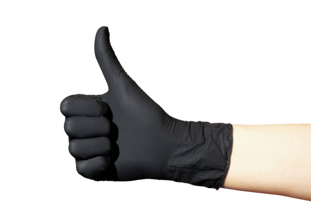  Женская рука в черной перчатке показывает знак ОК на белом фоне. Большой палец поднят
 - Фото, изображение