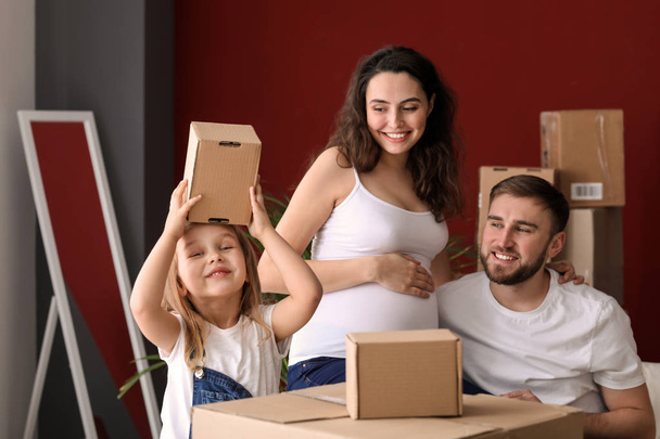 Happy family expecting baby with belongings at new home - Φωτογραφία, εικόνα