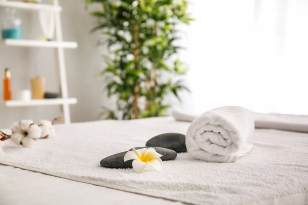 Pierres de massage et serviettes sur la table dans le salon de spa
 - Photo, image