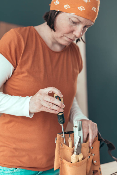 Female carpenter organizing tool belt set - Φωτογραφία, εικόνα