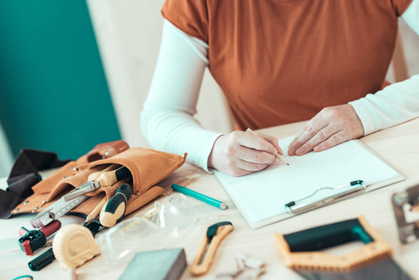 Autônoma carpinteiro feminino escrevendo notas do projeto
 - Foto, Imagem