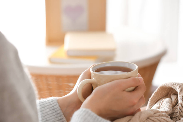 Молода жінка п'є гарячий чай вдома, крупним планом
 - Фото, зображення