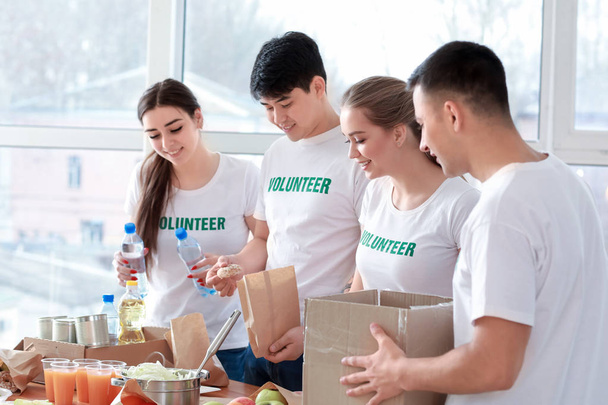 Jovens voluntários com alimentos para pessoas pobres dentro de casa
 - Foto, Imagem