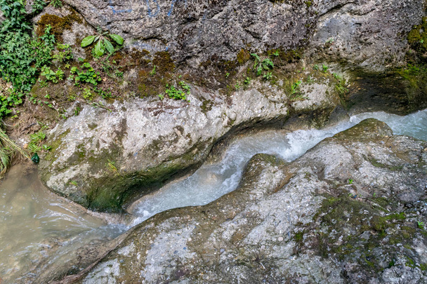 Pequeno rio de montanha flui através de rochas
 - Foto, Imagem