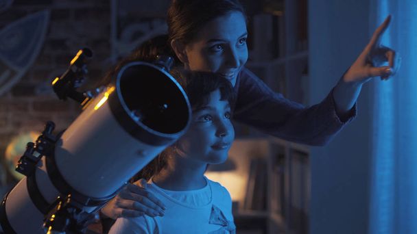 Cute sisters watching the stars with a telescope - Valokuva, kuva