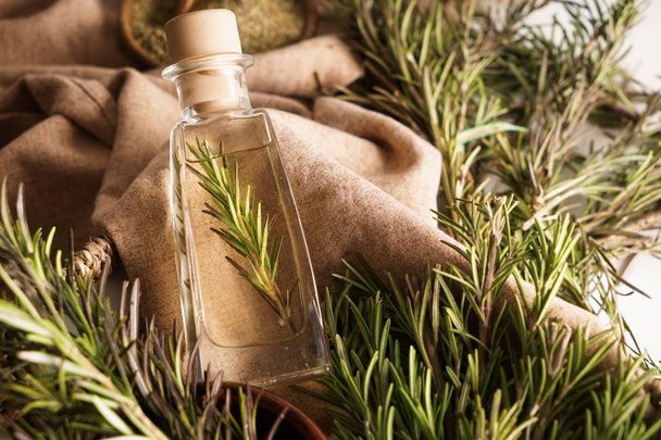 Bottle with rosemary oil on table - Photo, image