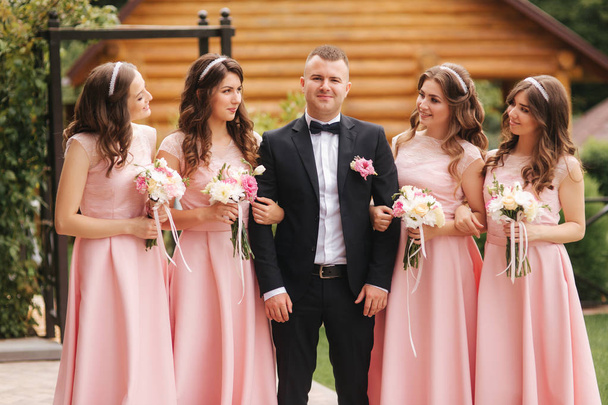 beau marié debout près de belle demoiselle d'honneur avec des bouquets
 - Photo, image