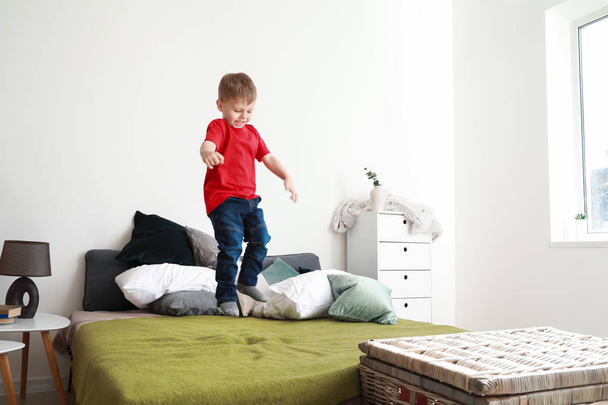 Ugrás az ágyban otthon boldog kisfiú - Fotó, kép