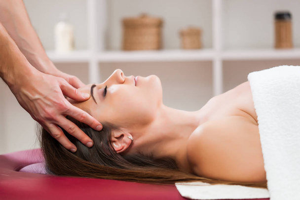 Mujer joven está disfrutando de masaje en el tratamiento de spa
.  - Foto, imagen