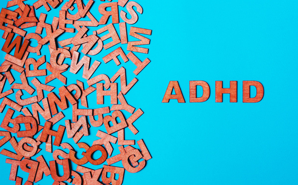 Palabra TDAH de letras de madera sobre fondo azul
 - Foto, Imagen