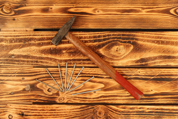 Nails and a hammer lying on the boards - Foto, imagen