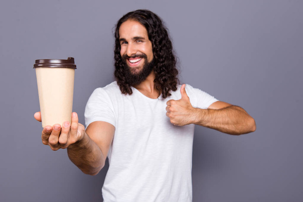 Portrait of his he nice cool attractive cheerful cheery wavy-haired guy giving takeaway cup showing thumbup isolated over gray violet purple pastel background - Photo, Image