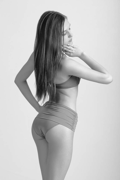 Slim body of young woman in bikini on white . Girl with healthy sporty figure - Fotó, kép