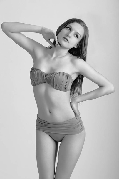 schlanke junge Frau im Bikini auf weißem Grund. Mädchen mit gesunder sportlicher Figur - Foto, Bild