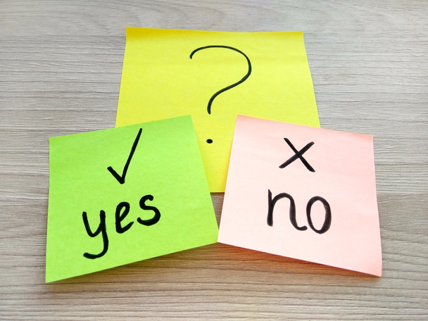 Yes or no question message on sticky notes on wooden table background. Problem solving and choice concept - Foto, afbeelding