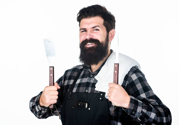 Essential cooking tools. Grill cook using cooking tool set of spatula and grilling fork. Happy hipster holding stainless steel cooking utensils. Bearded man with kitchen tools for cooking barbecue - 写真・画像