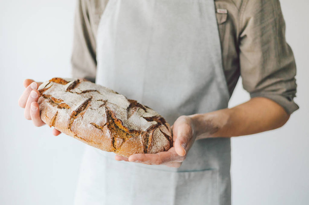 Baker or chef holding fresh made bread - Zdjęcie, obraz