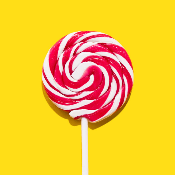 Red lollypop on yellow background - Photo, Image