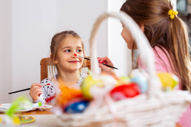 Happy easter! A beautiful child girl painting Easter eggs. - Foto, Bild