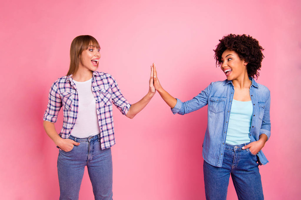 Close up photo two cheer diversity she her ladies different race skin hold clap arms amazed glad great company wear casual jeans denim checkered shirt clothes outfit isolated pink background - Zdjęcie, obraz