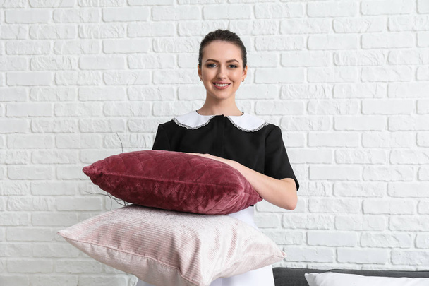 Piękna gospodyni kobiece z miękkimi poduszkami w pokoju - Zdjęcie, obraz