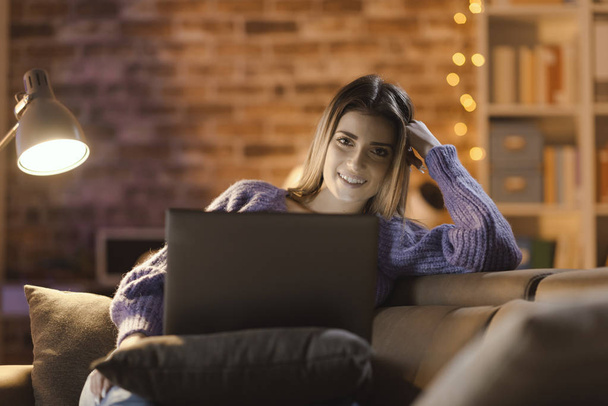 Kobieta, relaksujące i oglądania filmów na jej laptopie - Zdjęcie, obraz