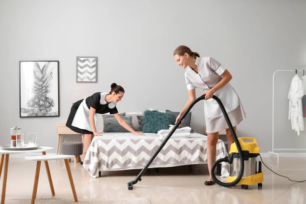 Beautiful female housekeepers working in room - Фото, зображення