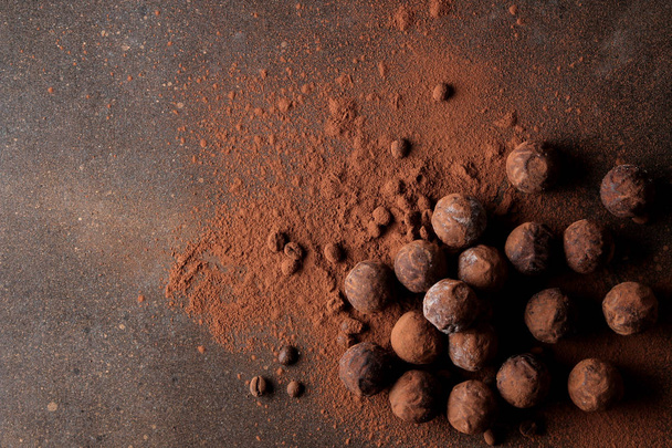 chocolates surtidos. bolas de caramelo de diferentes tipos de chocolate sobre un fondo oscuro. cacao y granos de café. vista superior
 - Foto, imagen