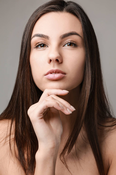 Portrait of beautiful woman with healthy skin on grey background - Fotografie, Obrázek