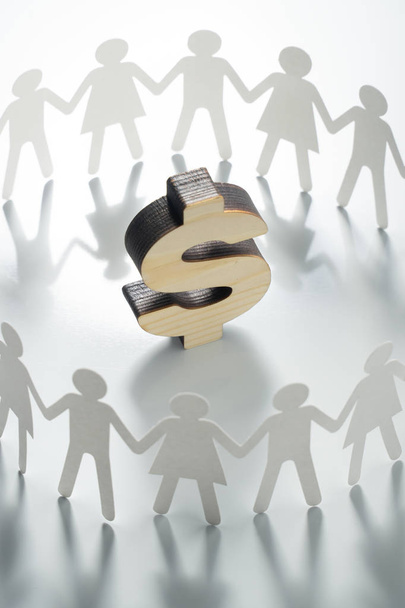 Circle of paper people holding hands in front of big dollar sign. Consumerism, economy concept. - Foto, imagen