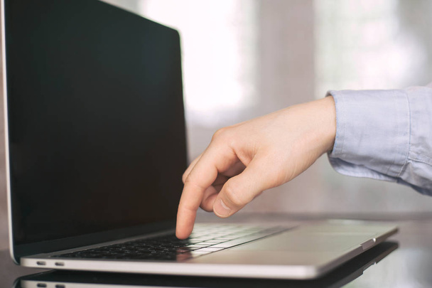 Один палець натискає кнопку клавіатури в ноутбуці з розмитим
 - Фото, зображення