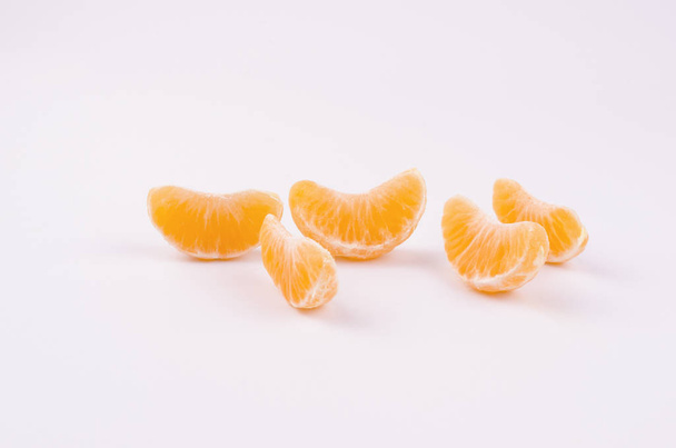 A few pieces of mandarin on a white background - Фото, изображение