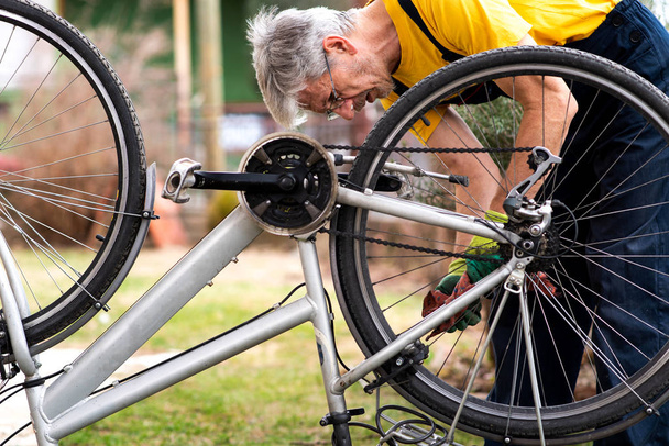 Man maintaining his bicycle for the new season - Photo, Image