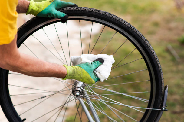 Man reinigen fiets band voor nieuwe seizoen - Foto, afbeelding