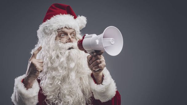 Santa Claus shouting with a megaphone - Фото, изображение