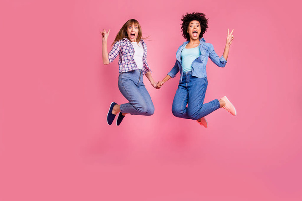 Full length body size view of two person nice attractive charming cheerful funny crazy funky girls holding hands showing v-sign isolated over pink pastel background - Foto, imagen