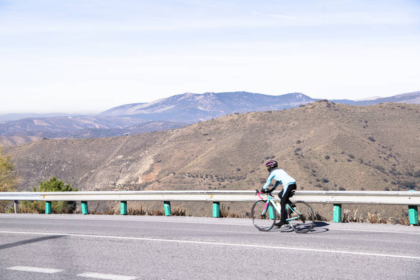 Highway in Spain with cyclist to mountains Sierra Nevada - Фото, зображення